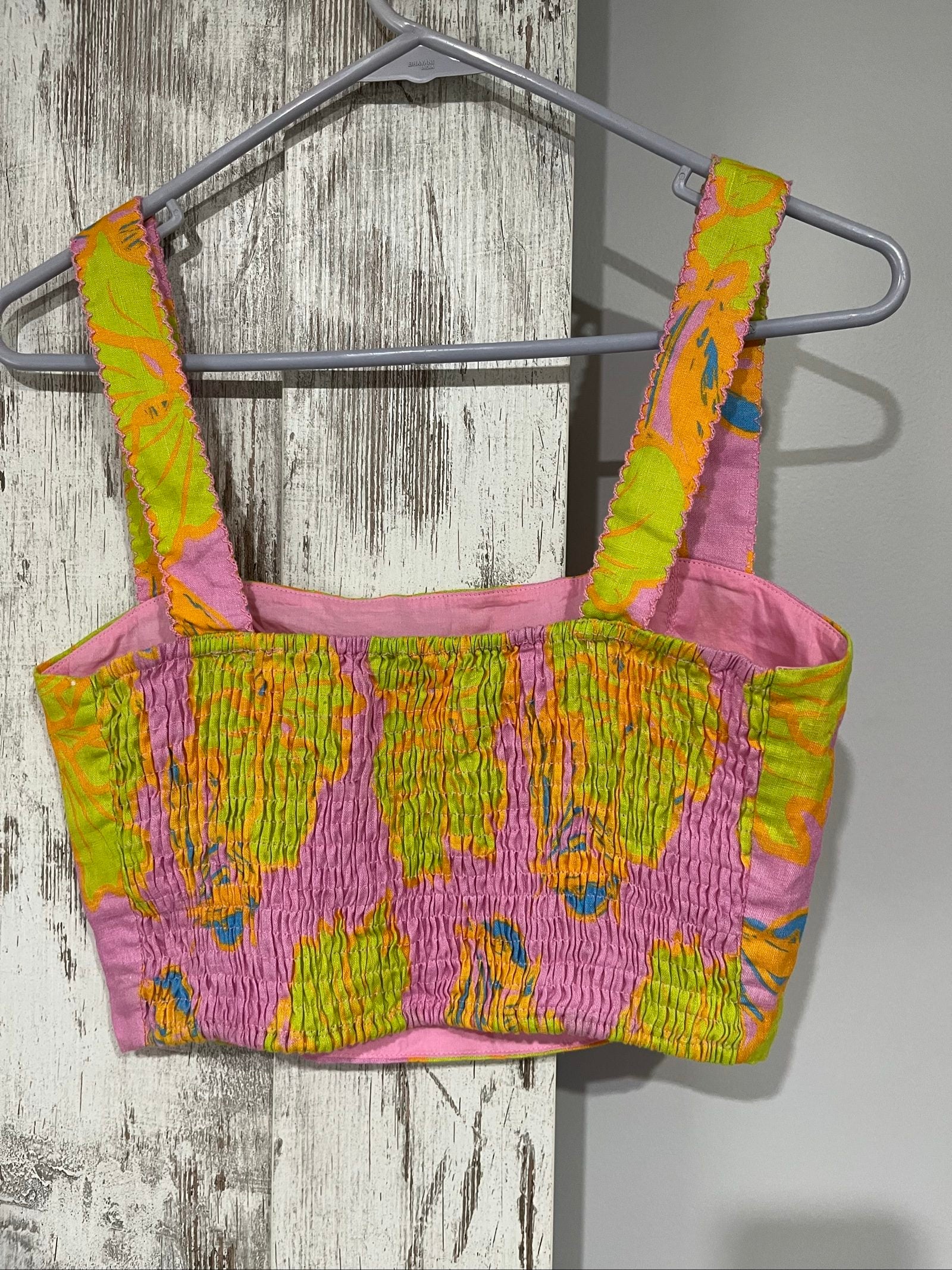 Versify floral crop top in pink, green, and orange, wide straps, smocked back, linen material.