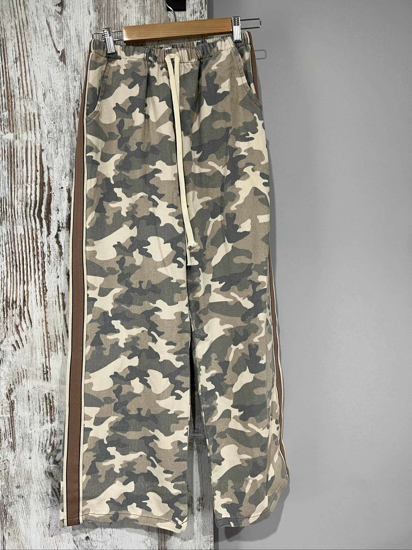 By Frankie beige and grey camo print wide-leg trousers with brown side stripes.