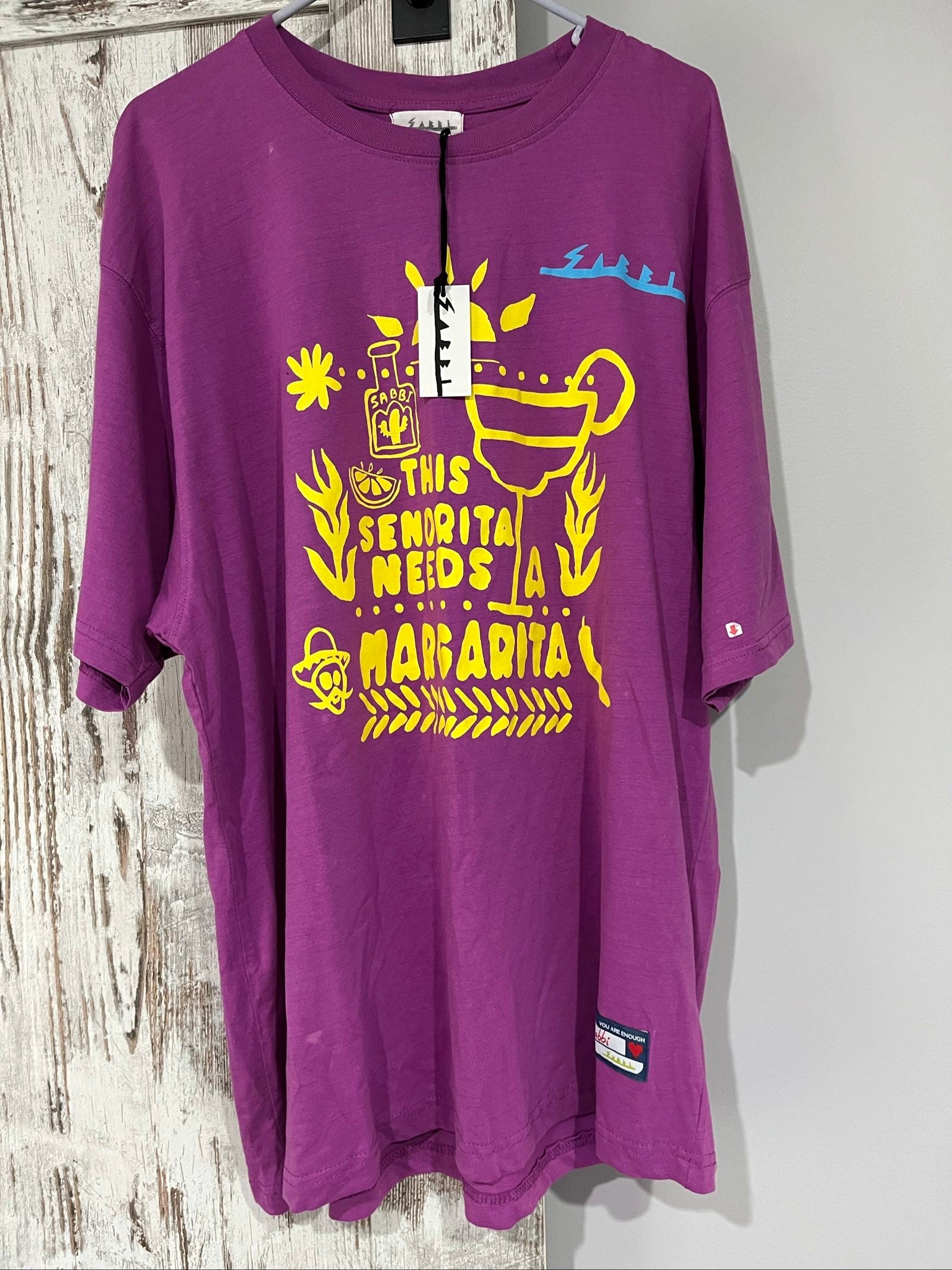 SABBI vintage graphic t-shirt purple with bold yellow front and multicoloured back print.