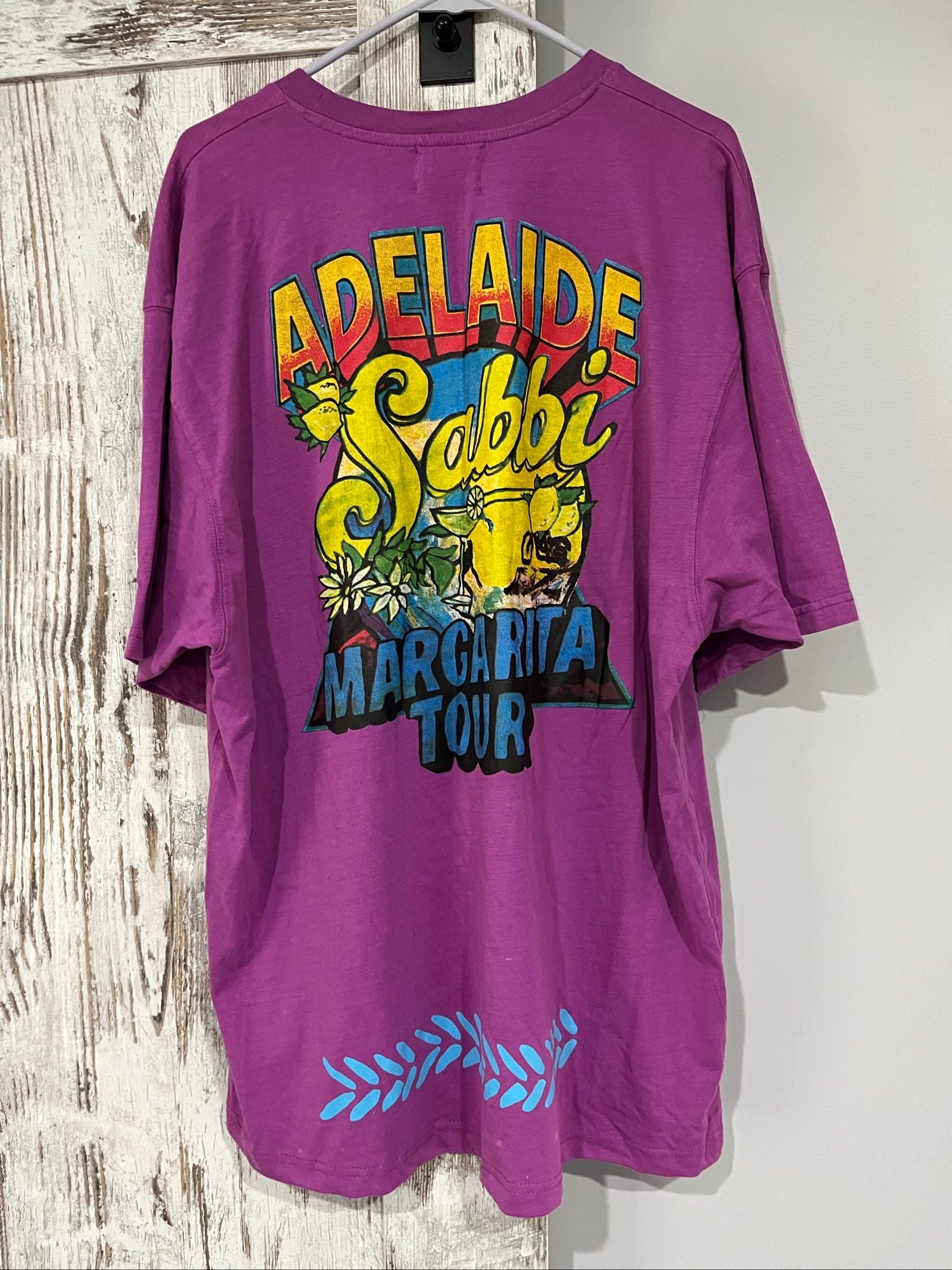 SABBI vintage graphic t-shirt purple with bold yellow front and multicoloured back print.