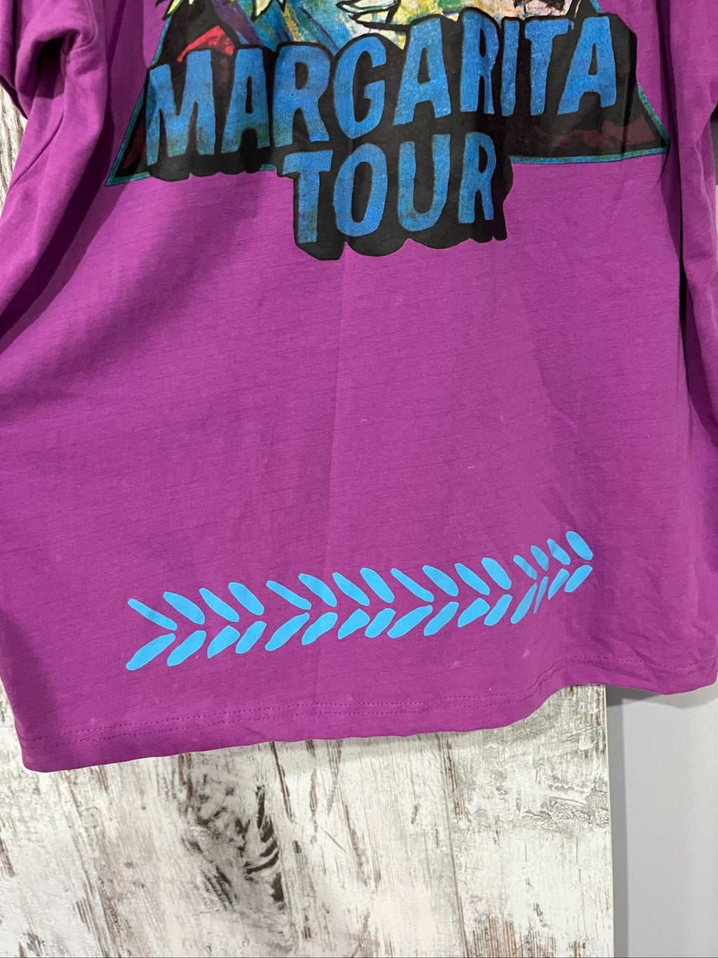 SABBI vintage graphic t-shirt purple with bold yellow front and multicoloured back print.