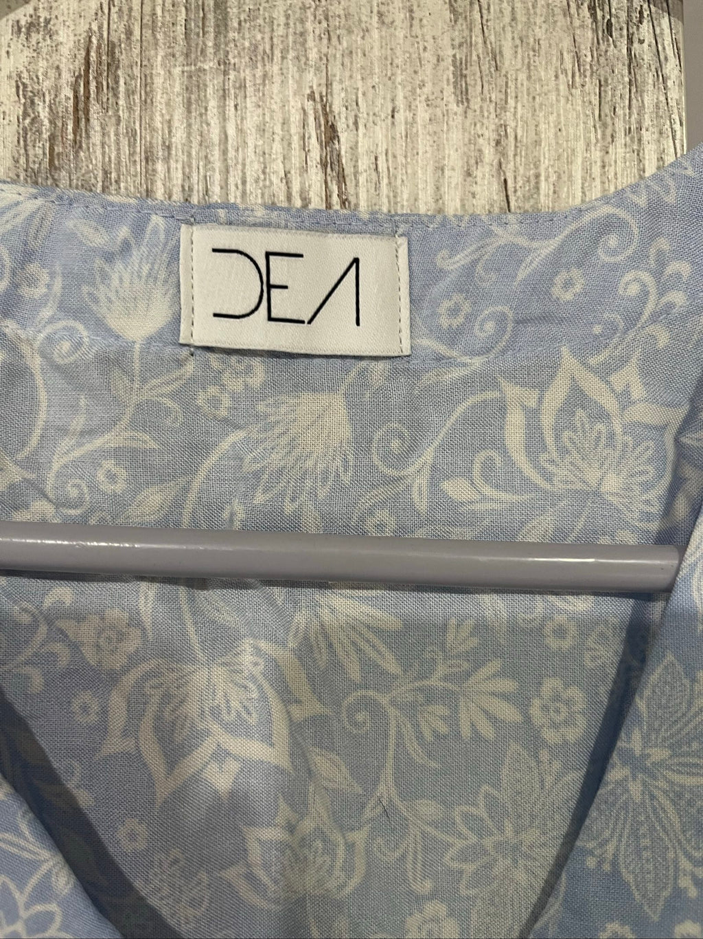 DEA blue and white floral button-up dress with fabric-covered buttons and gathered waist seam.