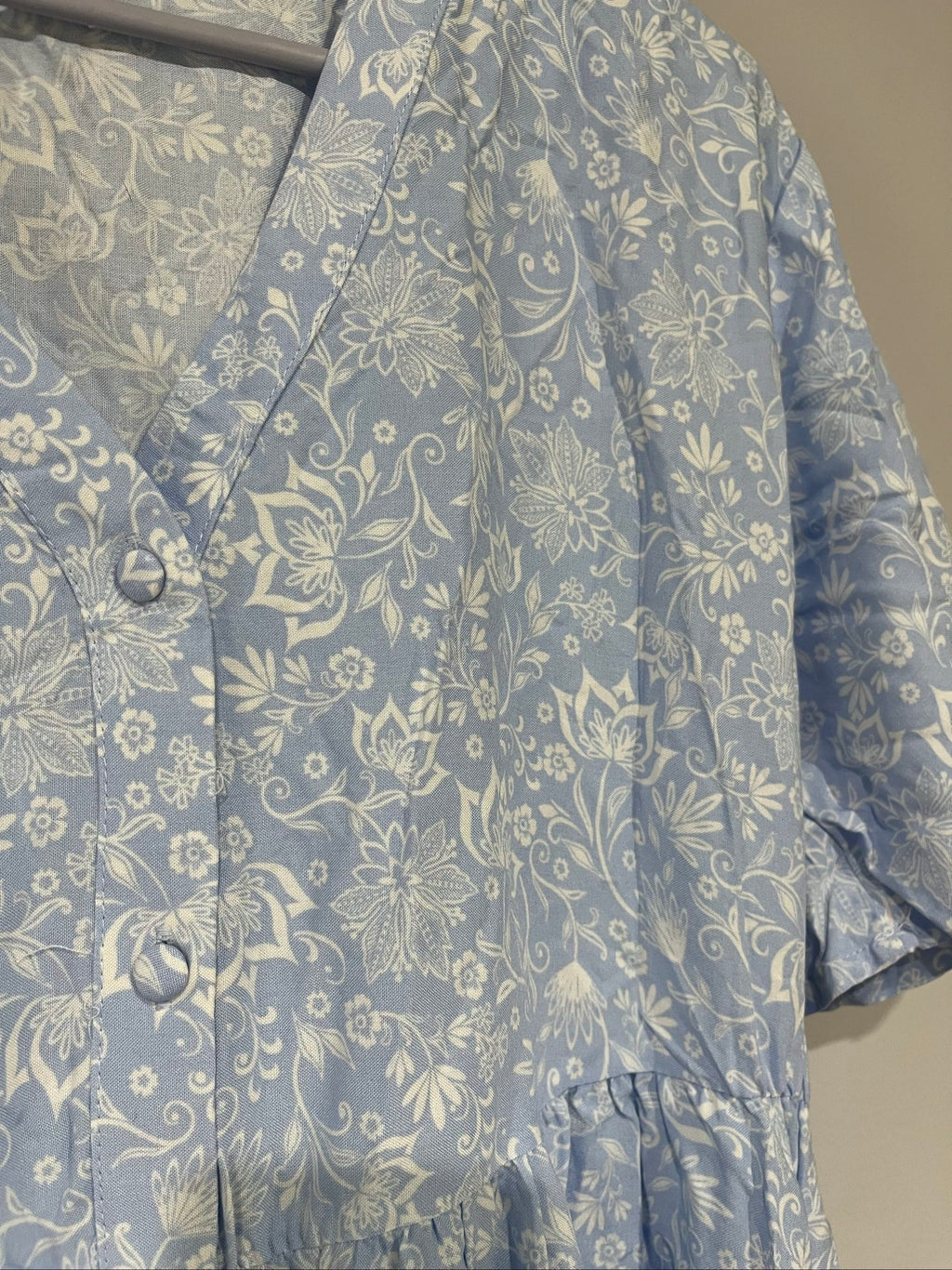 DEA blue and white floral button-up dress with fabric-covered buttons and gathered waist seam.