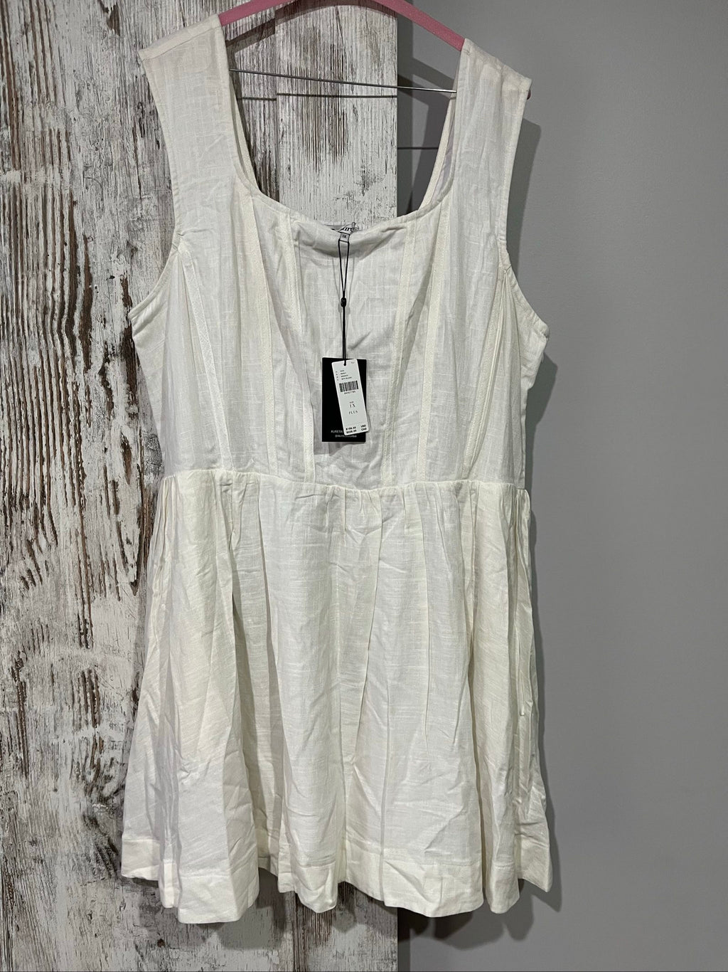 Aureta white sleeveless dress with gathered waist and smocked back detailing.