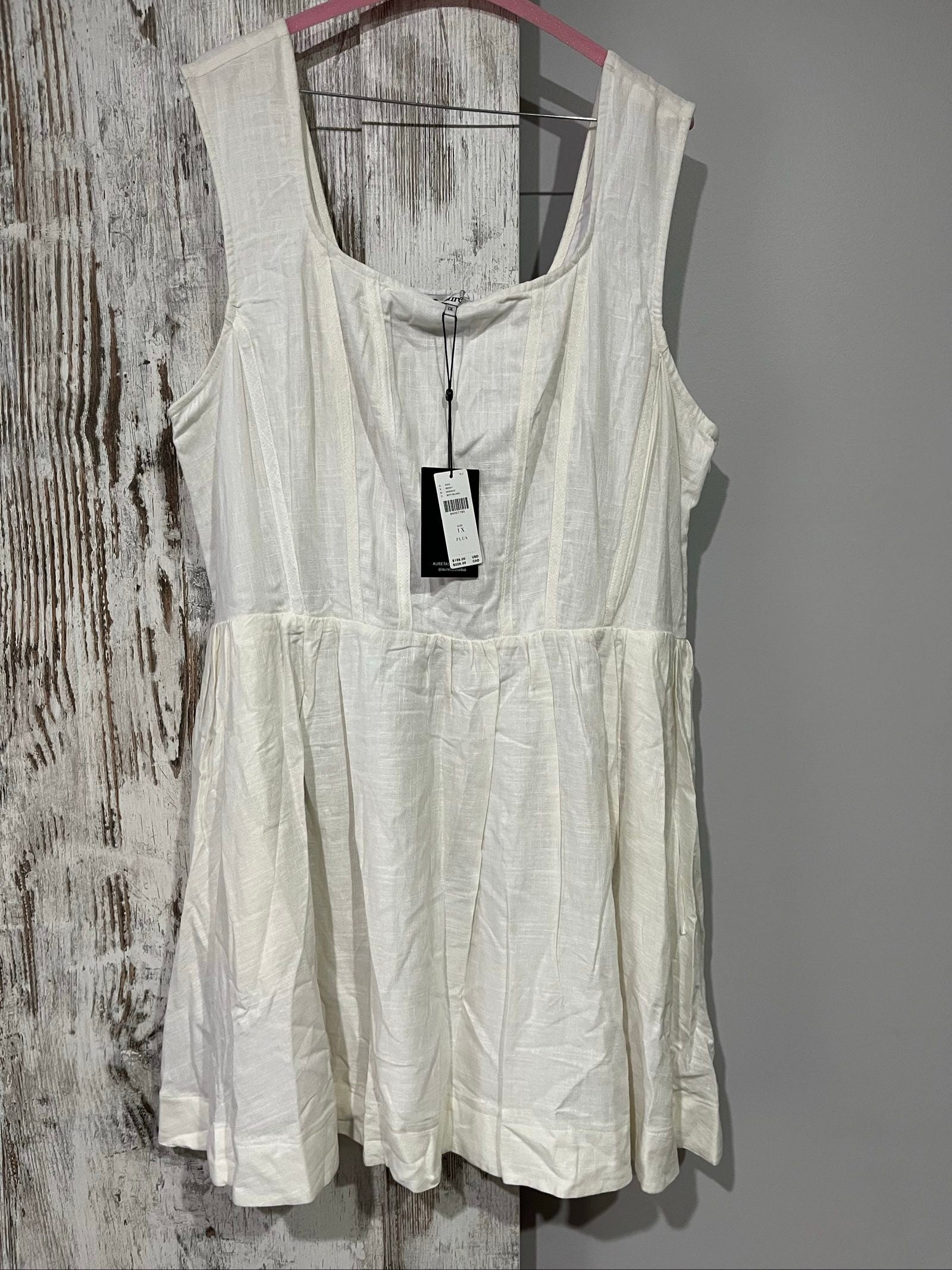 Aureta white sleeveless dress with gathered waist and smocked back detailing.