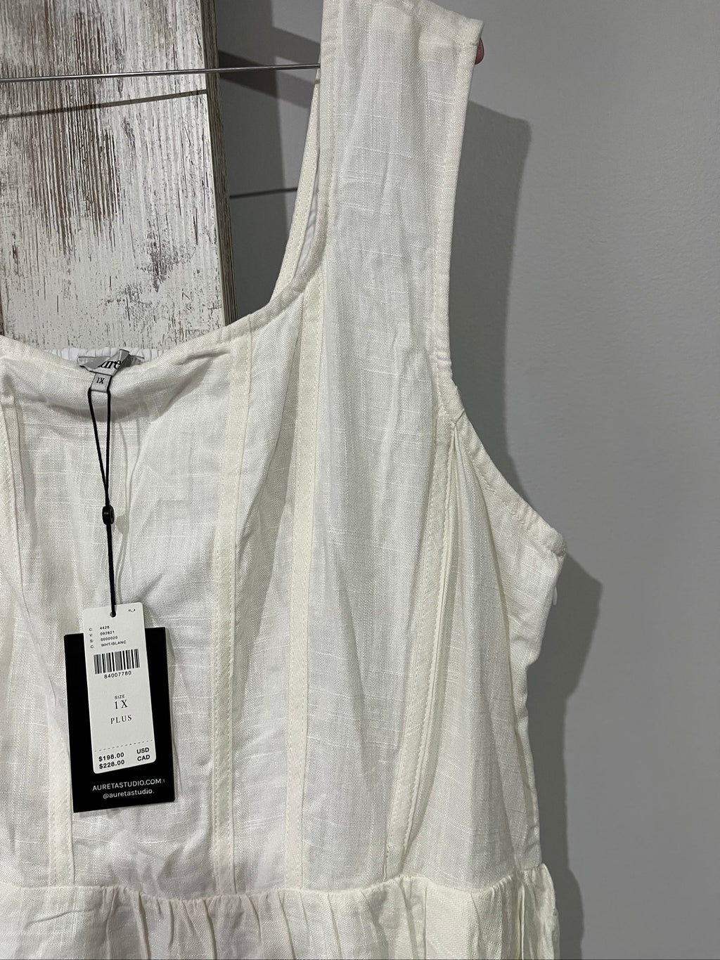 Aureta white sleeveless dress with gathered waist and smocked back detailing.