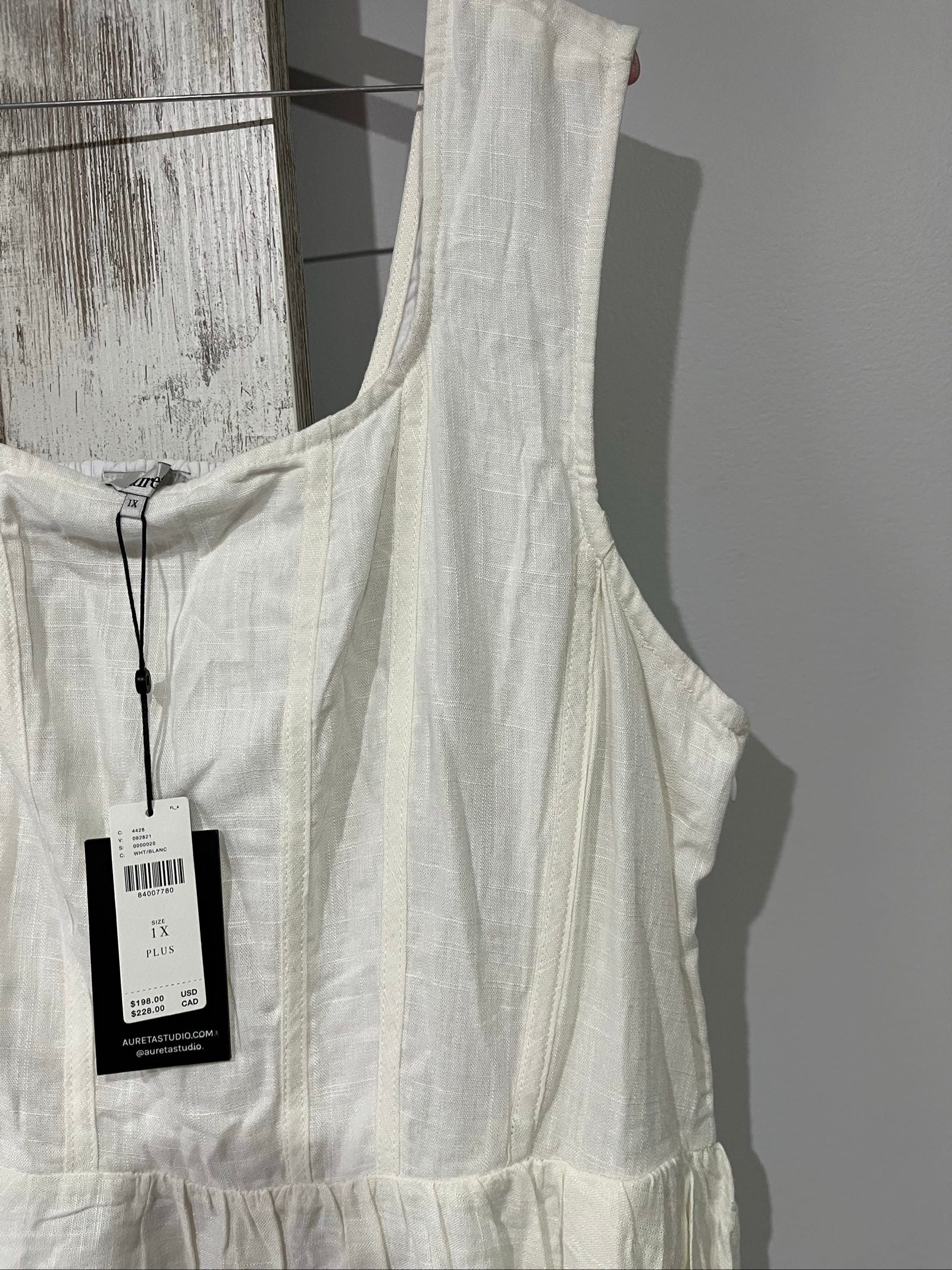 Aureta white sleeveless dress with gathered waist and smocked back detailing.