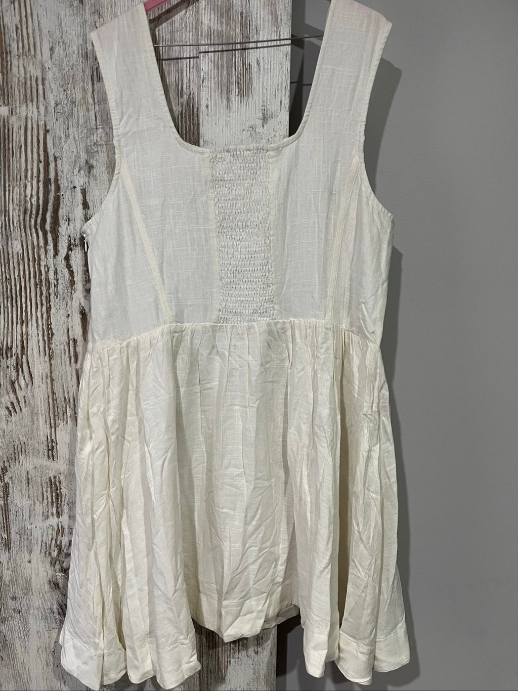 Aureta white sleeveless dress with gathered waist and smocked back detailing.