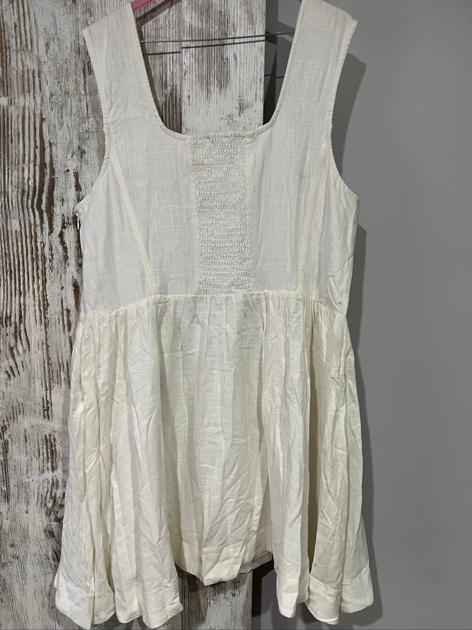 Aureta white sleeveless dress with gathered waist and smocked back detailing.
