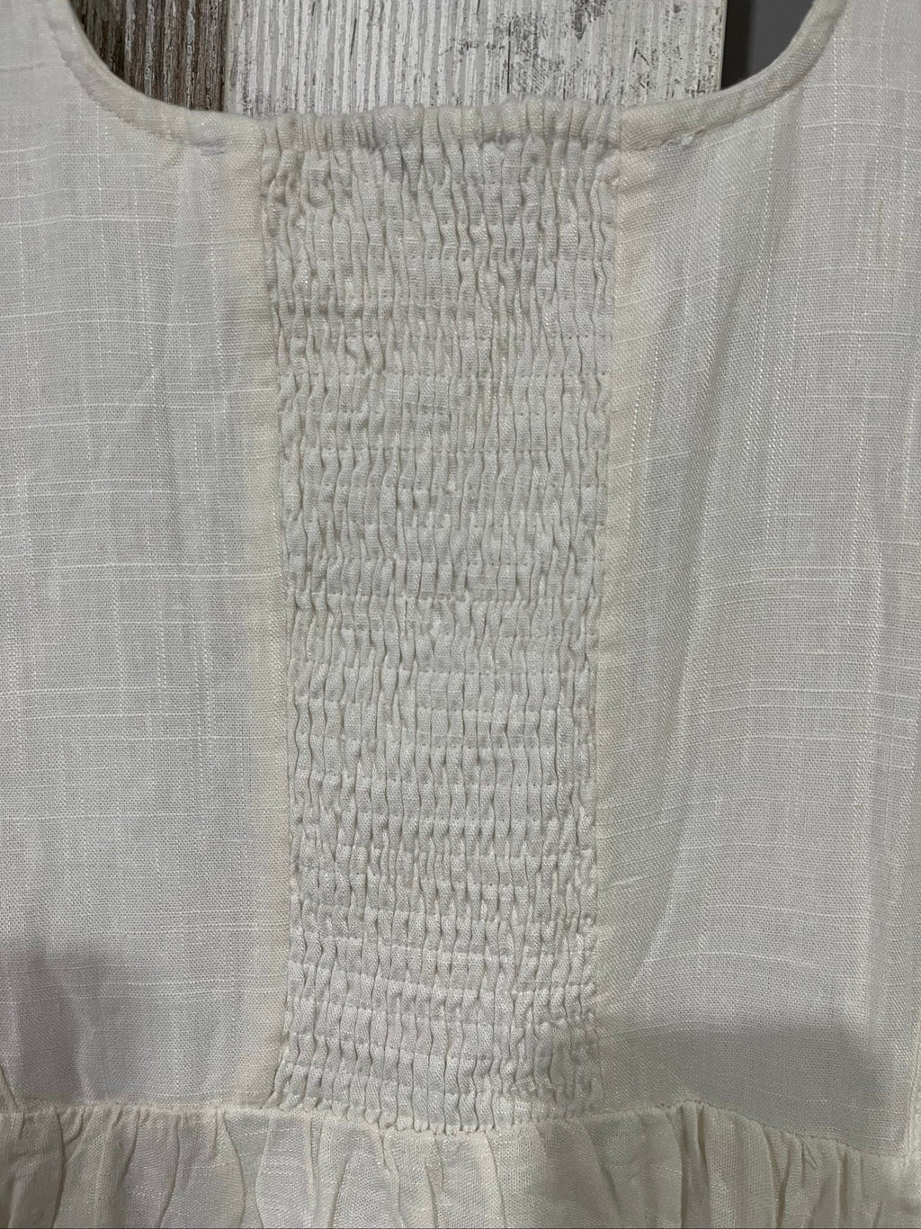 Aureta white sleeveless dress with gathered waist and smocked back detailing.