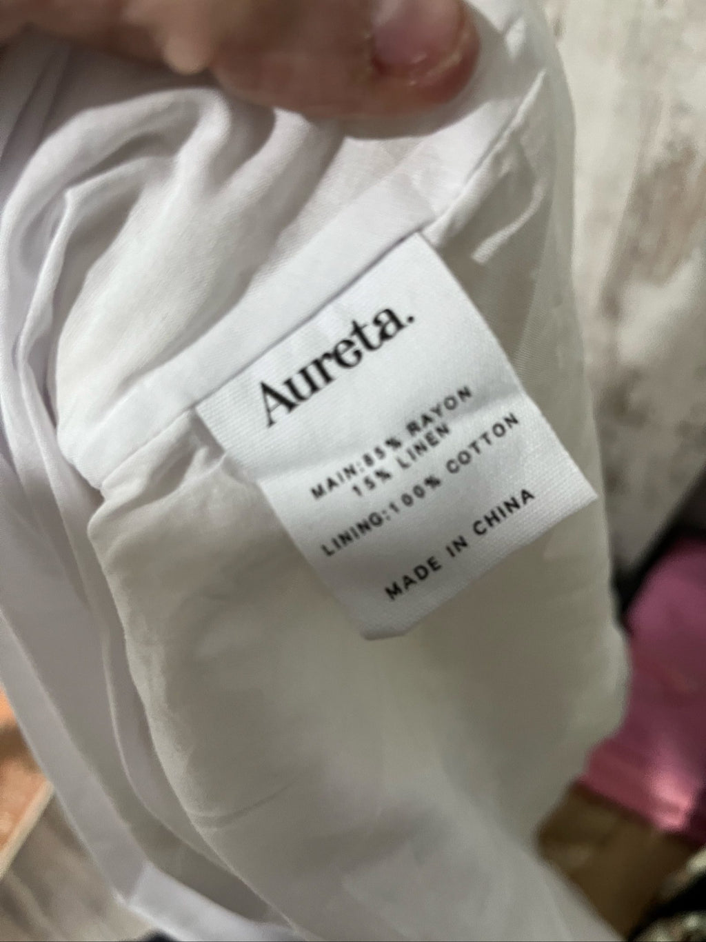Aureta white sleeveless dress with gathered waist and smocked back detailing.