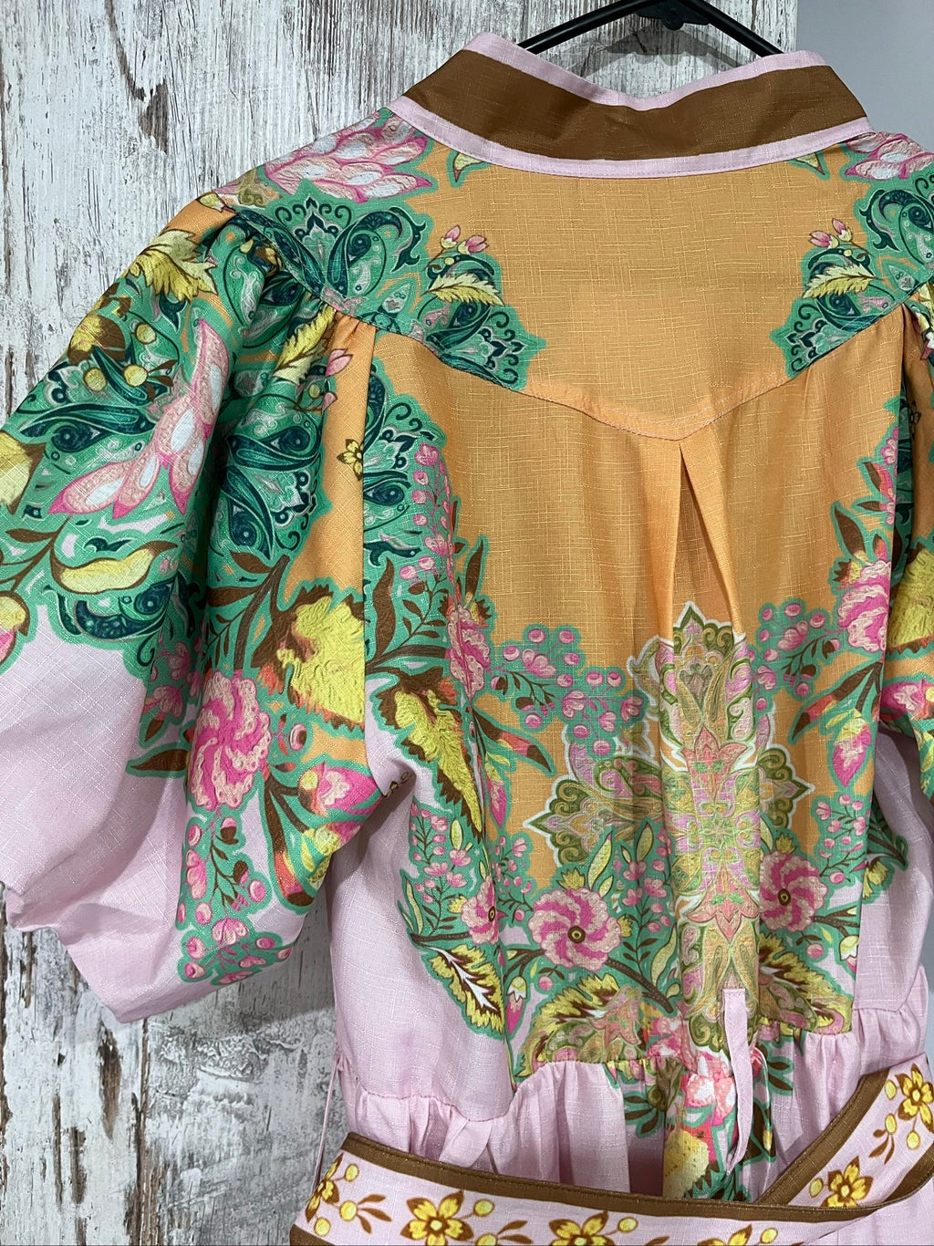 27SE brown midi dress with pink and green floral print, short puff sleeves, matching belt.