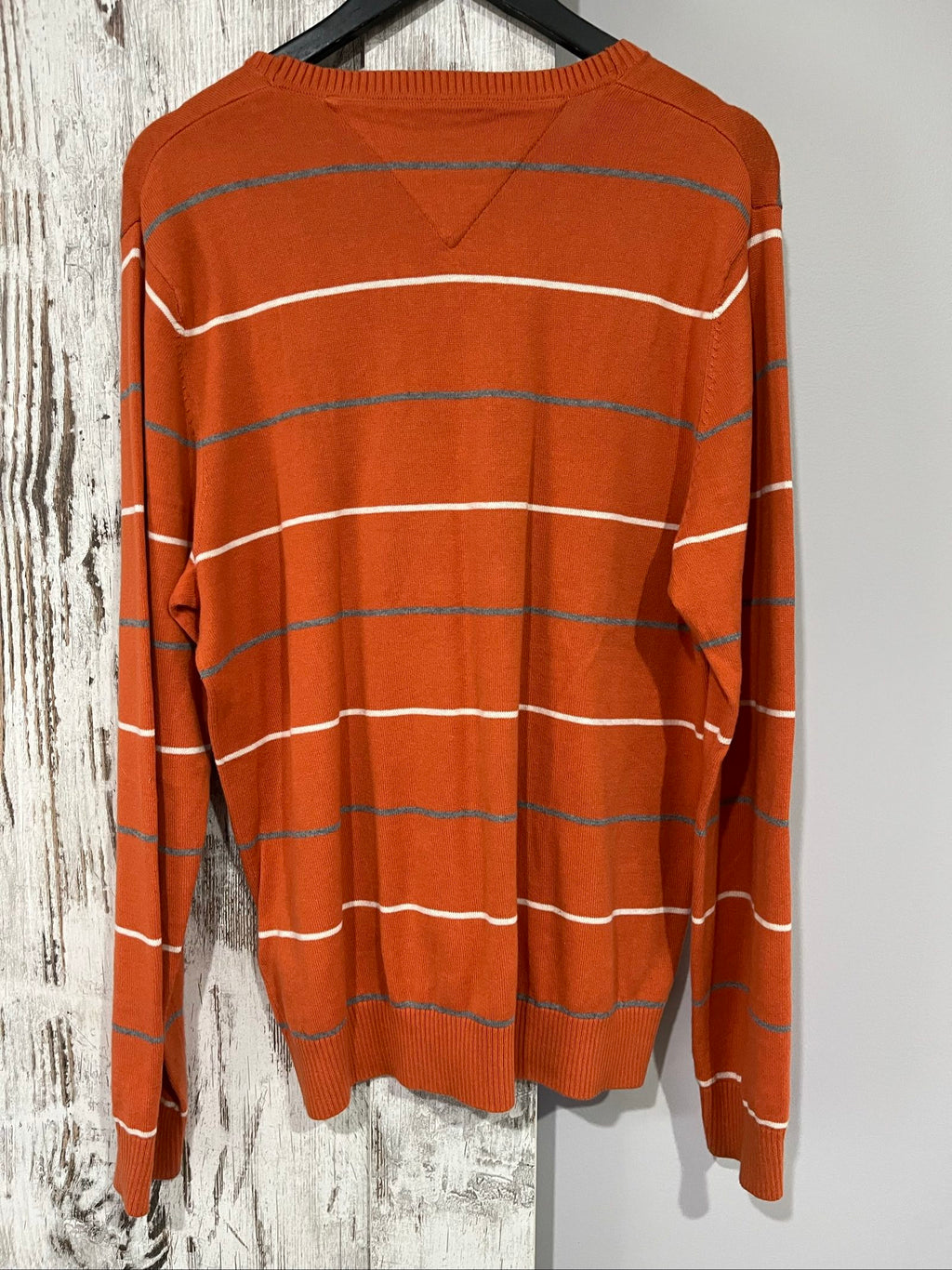 Tommy Hilfiger men's grey and white striped v-neck sweater with embroidered flag logo.