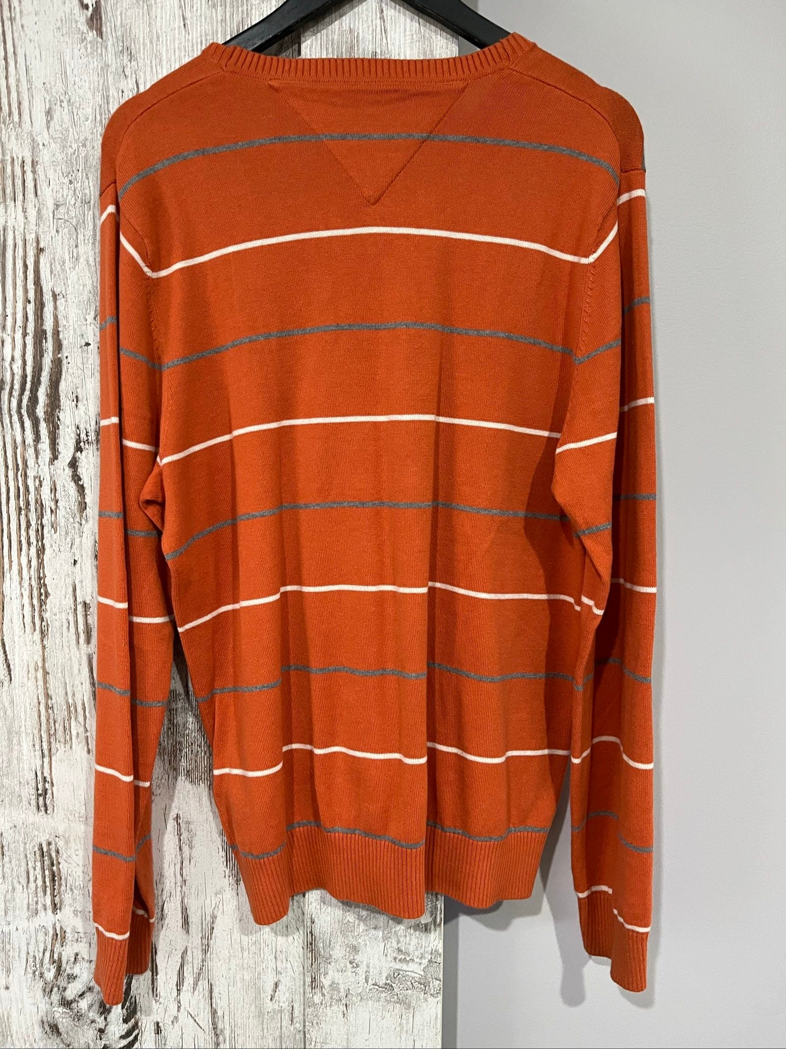 Tommy Hilfiger men's grey and white striped v-neck sweater with embroidered flag logo.