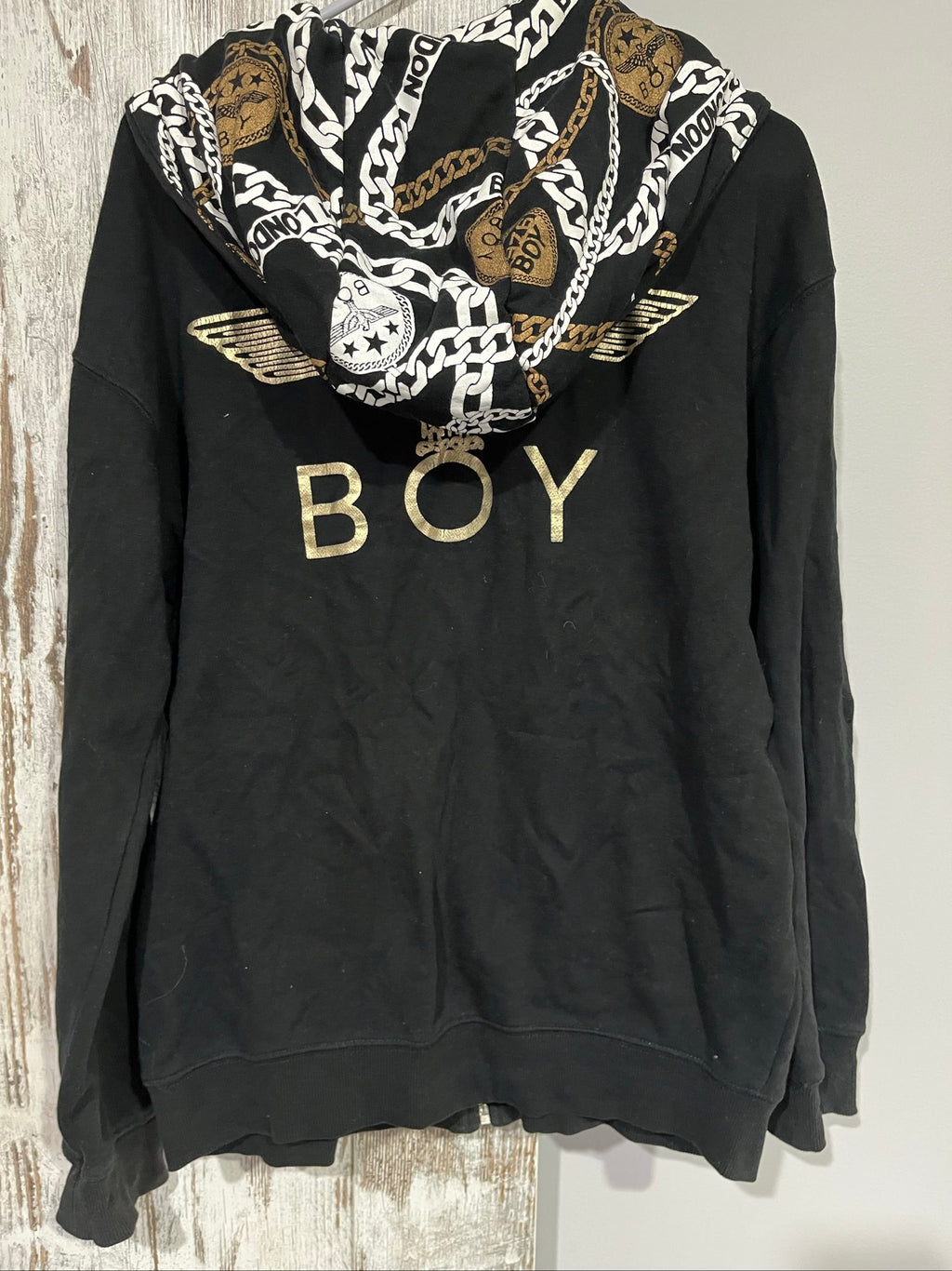 Boy London black zip-up hoodie with gold chain print and logo patch details.