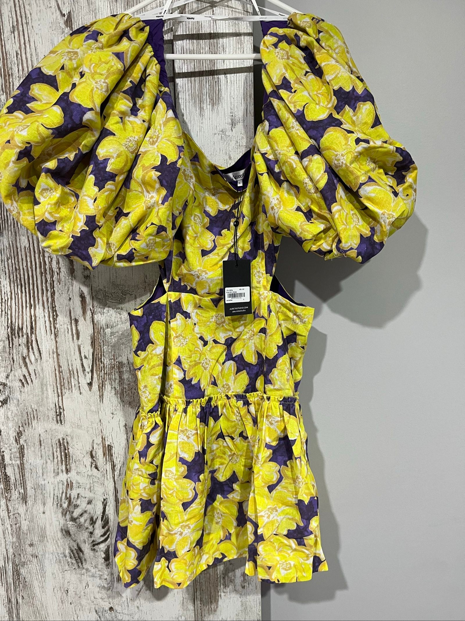 Aureta mini dress yellow and purple floral print with puff sleeves and cut-out waist.