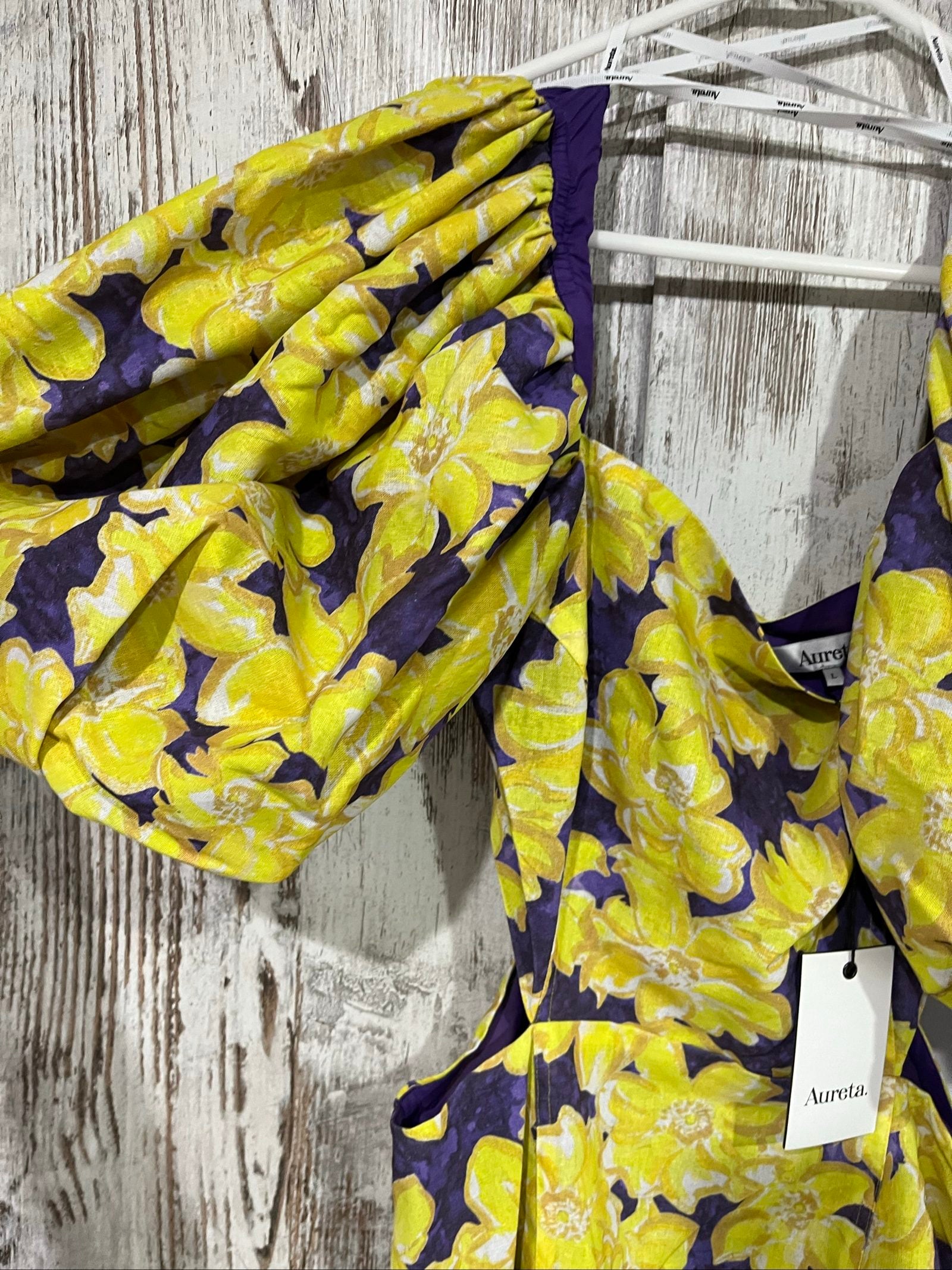 Aureta mini dress yellow and purple floral print with puff sleeves and cut-out waist.