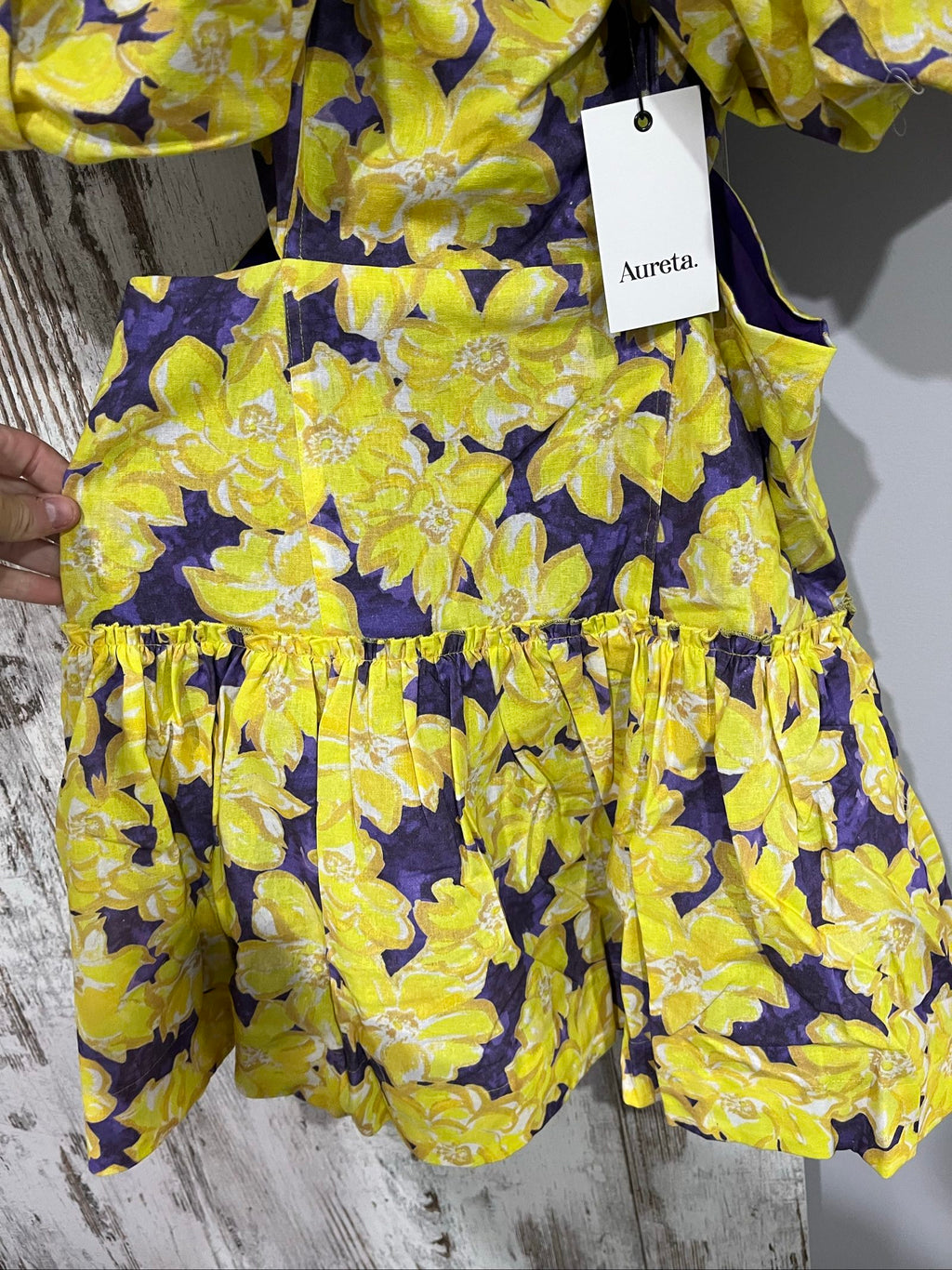 Aureta mini dress yellow and purple floral print with puff sleeves and cut-out waist.