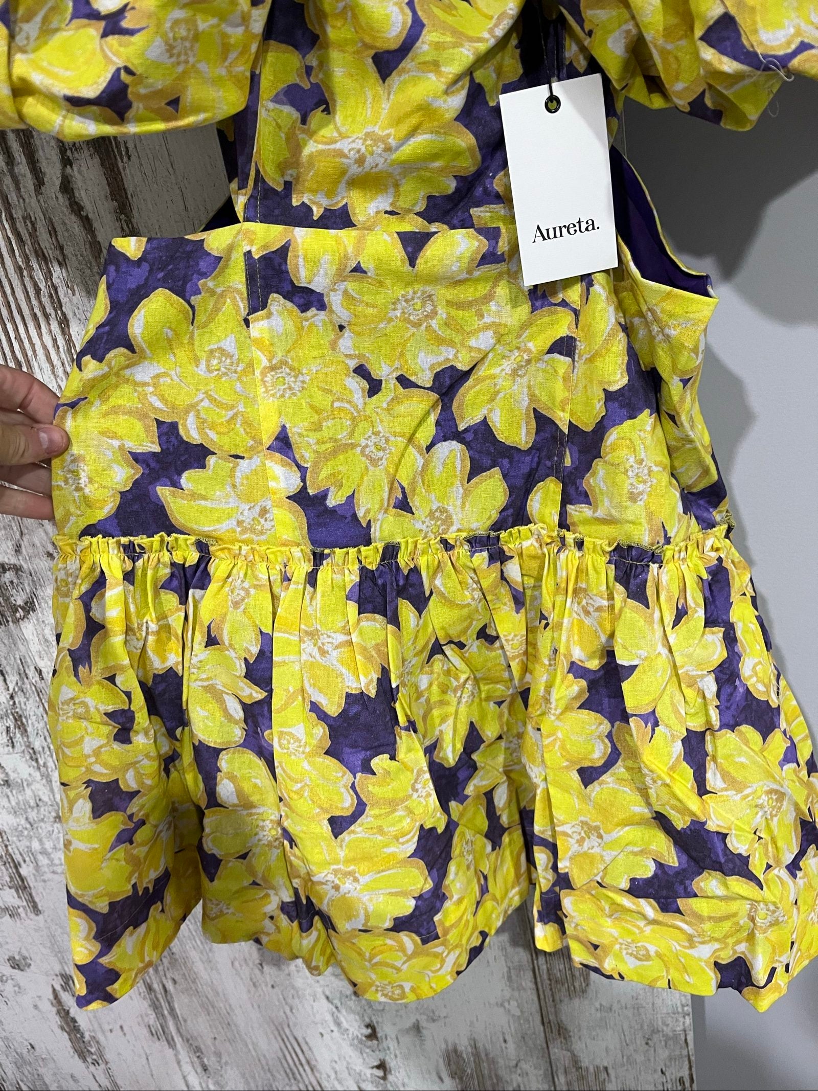 Aureta mini dress yellow and purple floral print with puff sleeves and cut-out waist.