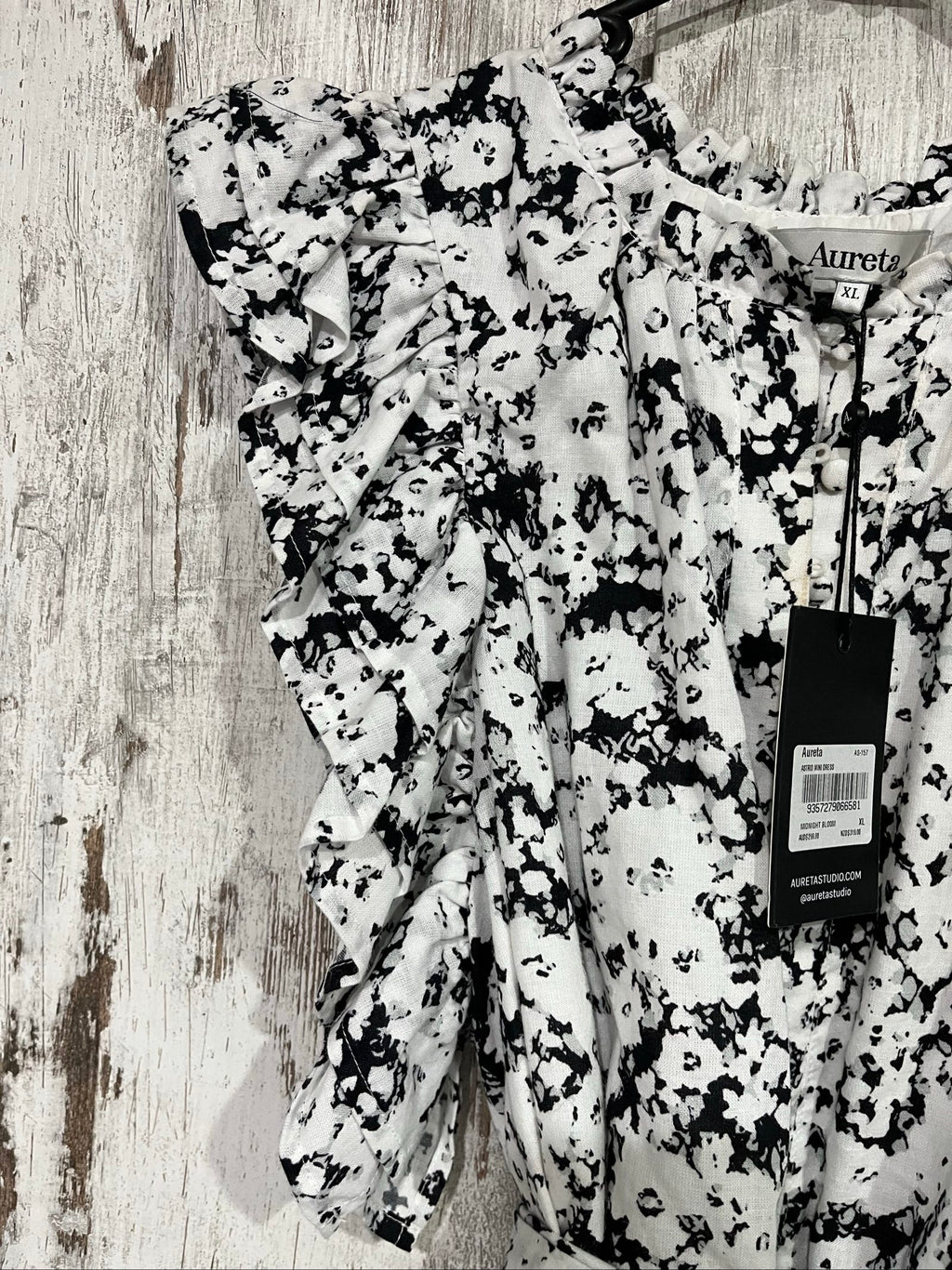 Aureta mini dress black and white abstract floral print with ruffle sleeves and buttons.