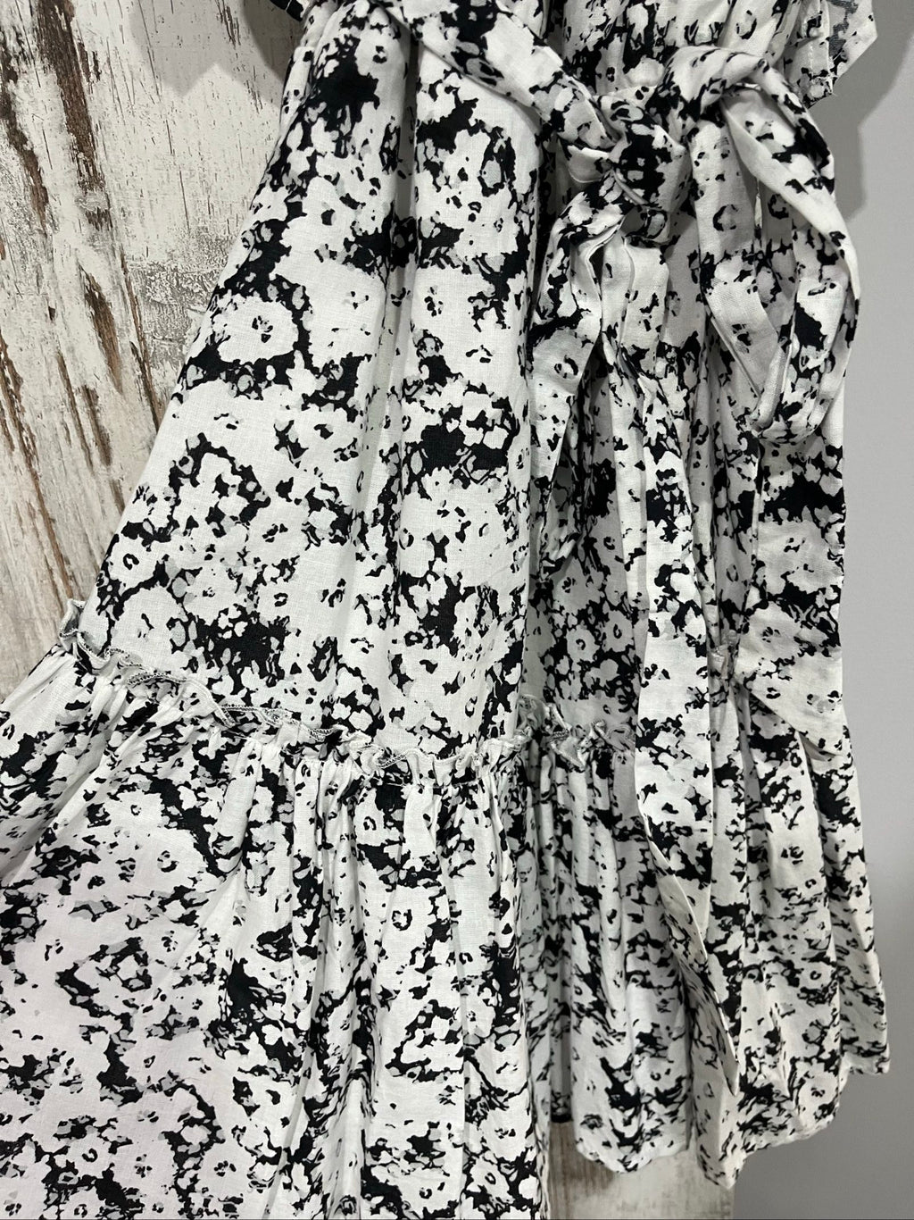 Aureta mini dress black and white abstract floral print with ruffle sleeves and buttons.