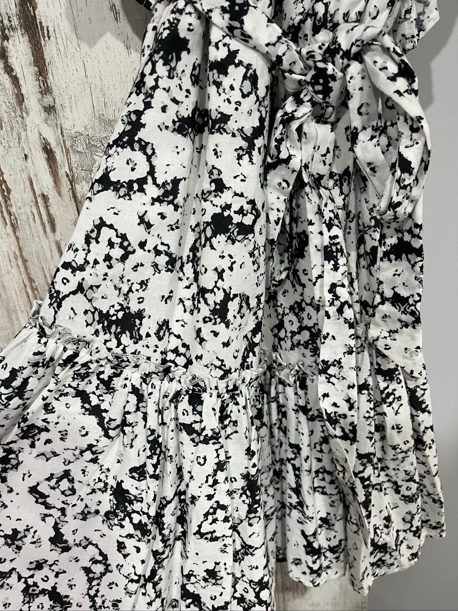 Aureta mini dress black and white abstract floral print with ruffle sleeves and buttons.