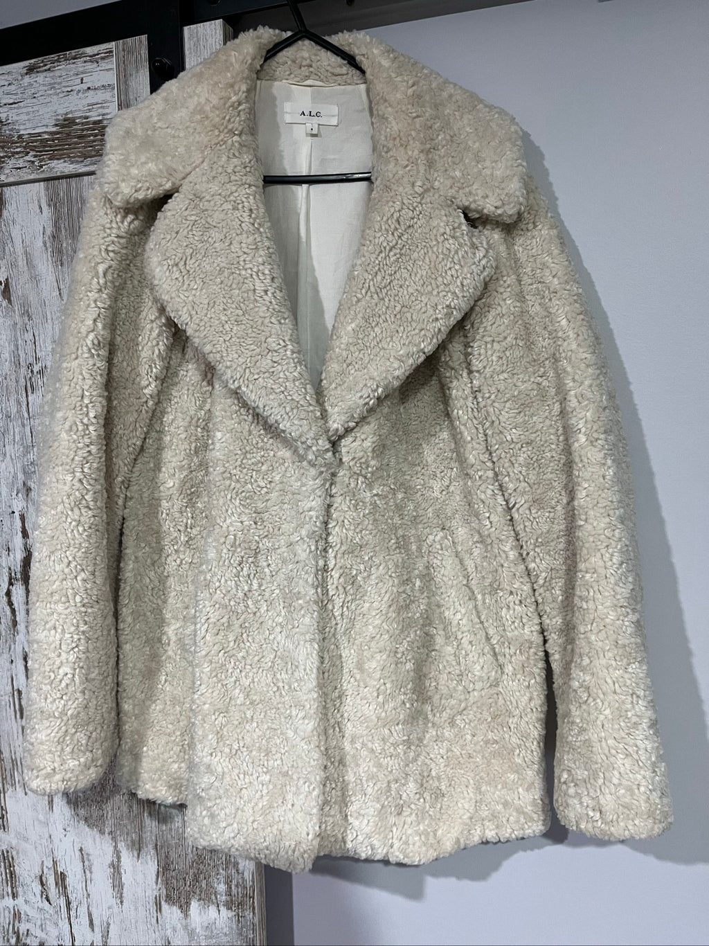 ALC beige faux shearling coat with wide collar and soft plush texture.