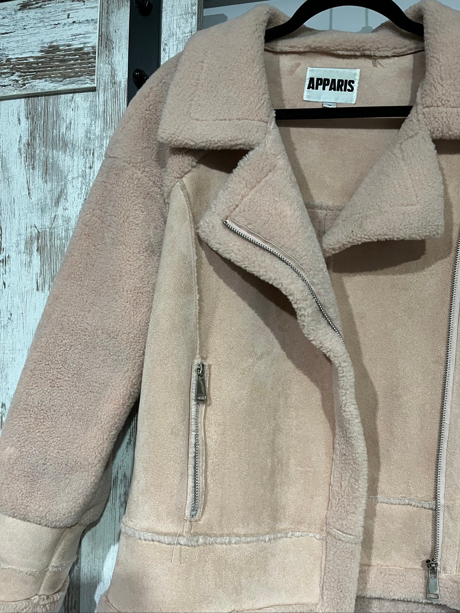 APPARIS beige biker jacket with faux shearling lining, zip-up front, and silver-tone hardware.