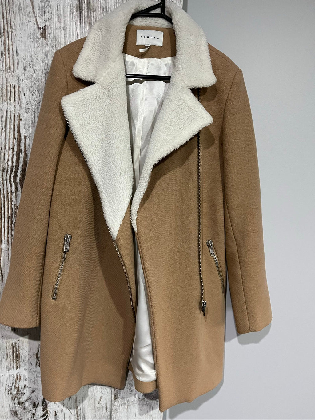 Sandro camel coat with white faux shearling collar and silver-tone zipper pockets.