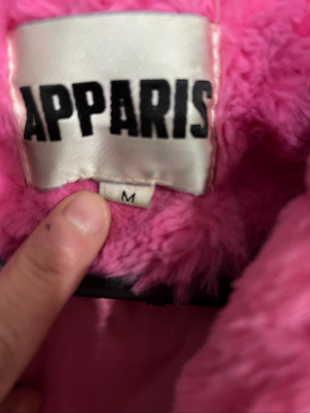 Apparis pink faux fur hooded jacket with snap-button closures and plush texture.