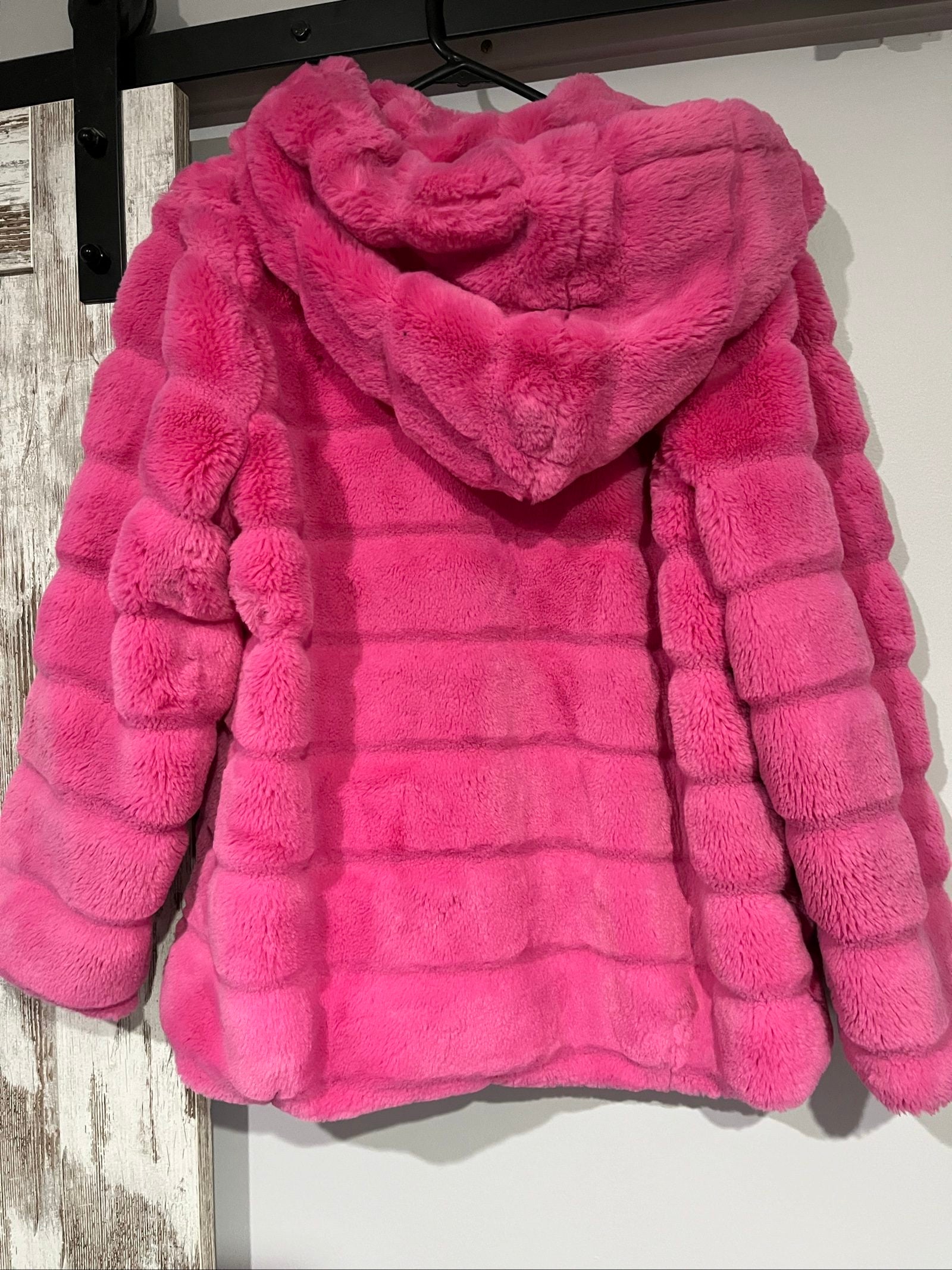 Apparis pink faux fur hooded jacket with snap-button closures and plush texture.