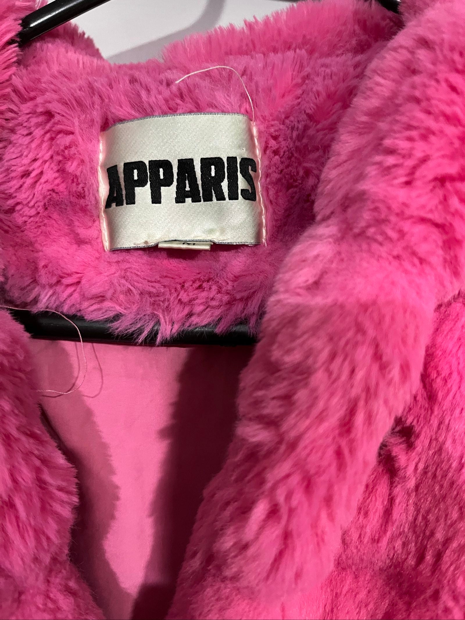 Apparis pink faux fur hooded jacket with snap-button closures and plush texture.