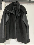 Unreal Fur black vegan shearling jacket with zip front, shearling cuffs, and buckle detail.