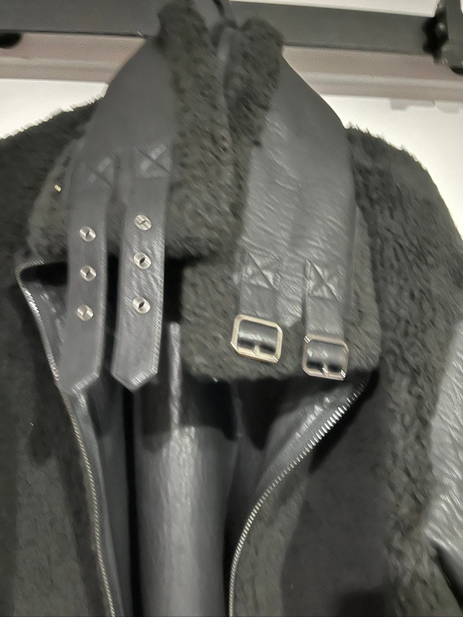 Unreal Fur black vegan shearling jacket with zip front, shearling cuffs, and buckle detail.